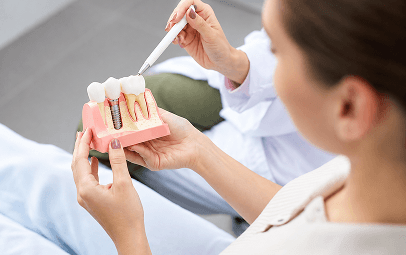 Dentist explaining a dental implant using a model