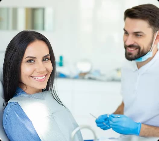 Dentist and patient smiling together in a treatment room